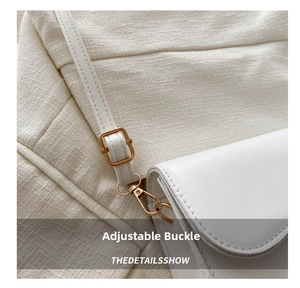 Detail of white saddle bag with golden adjustable buckle and precise stitching