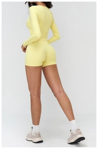 Back view of yellow high-waisted yoga shorts and long-sleeve crop top set