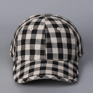 Detail view of the black and white checkered linen baseball cap with a classic curved brim
