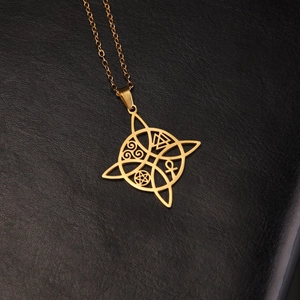 Detail of a golden stainless steel Celtic knot pendant featuring Ankh and Pentagram symbols