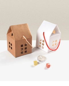 Detail of house-shaped kraft and white gift boxes with rope handles and hollow-out design
