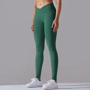 Dettaglio della vita alta incrociata a V sui pantaloni da yoga senza cuciture verde scuro