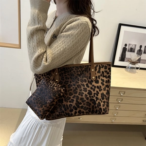 Large leopard print tote bag with matching pouch shown as a stylish shoulder bag