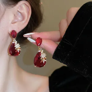 Close-up of vintage red water-drop crystal earrings with floral gold details on model