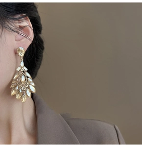 Close-up of luxury champagne gold water drop earrings with faceted crystals on a model