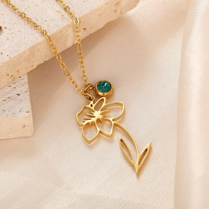Detail of 18k gold plated stainless steel necklace with emerald crystal and flower charm