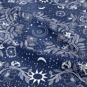 Detailed view of bohemian tapestry fabric with sun, moon, and floral astrology patterns
