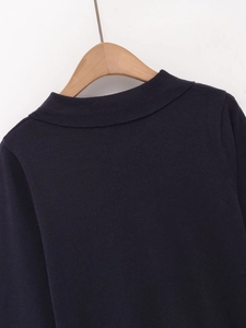 Dettaglio delle cuciture sullo scollo e trama in maglia blu scuro della polo