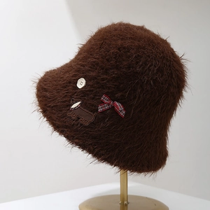 Détail d'un chapeau bob en fausse fourrure avec nœud écossais et broderie de teckel
