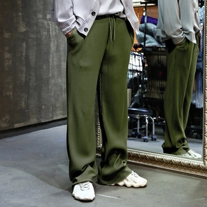 Army green wide-leg trousers featuring vertical ribbed texture and adjustable drawstring waist