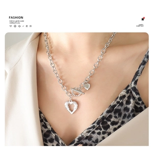Macro detail of silver heart necklace with OT toggle clasp on professional model