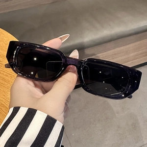 Detailed view of black rectangle sunglasses with wide temples and dark tinted lenses