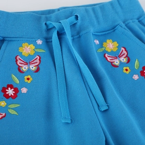 Sky blue cotton joggers for girls featuring elastic waistband and floral embroidery
