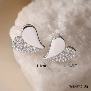 Macro detail of silver heart stud earrings with size 1.1x1.3cm and 3g weight on stone