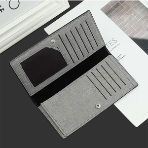Detail of grey canvas bifold long wallet showing internal card slots and buckle closure