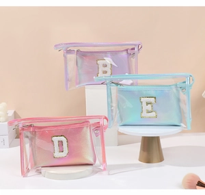 Dettaglio di trousse laser con ricamo di lettere 3D e strato esterno in PVC trasparente