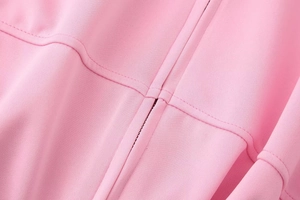 Detailed macro view of pink bomber jacket zipper and professional stitching craftsmanship
