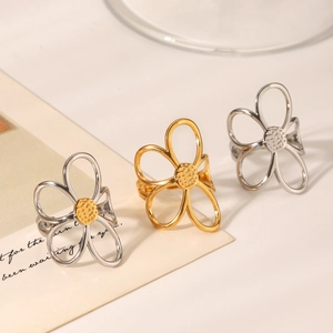 Detail of hollow floral rings in gold, silver and mixed tones on minimalist background