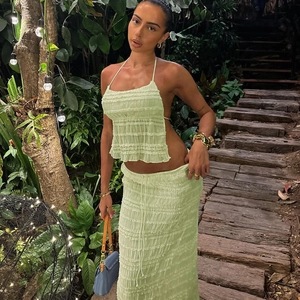 Détail du tissu plissé vert clair sur un ensemble top dos nu et jupe longue