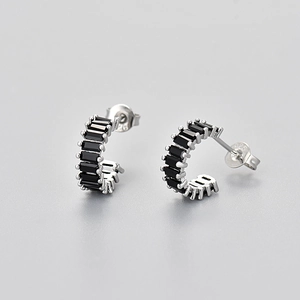 Macro view of 925 sterling silver hoop earrings set with square black zircon stones