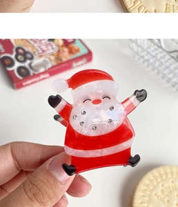 Détail d'une pince à cheveux Père Noël en acrylique avec des strass brillants décoratifs