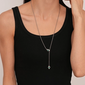 Détail d'un collier en Y avec pierres vertes en goutte et cristaux pavés sur un mannequin