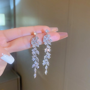 Macro detail of silver tassel earrings with marquise-cut zircons in leaf design