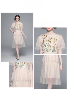Detail of floral embroidery and sequins on light beige mesh tiered dress with flared sleeves