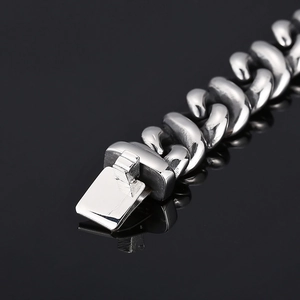 Macro detail of silver stainless steel Cuban link necklace with secure square clasp
