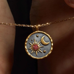Gold stainless steel sun moon necklace with a red birthstone and star engravings