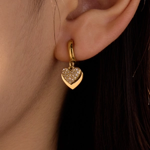 Boucles d'oreilles cœur en acier inoxydable doré avec zircons portées par un mannequin