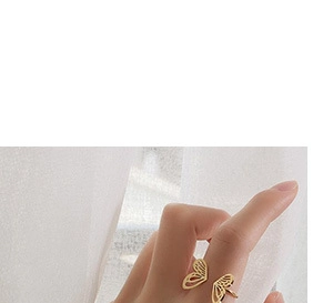 Detail of a golden butterfly open ring on finger showing its elegant and adjustable design