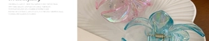 Detail of colorful plumeria hair claws in pink and blue on a white shell tray