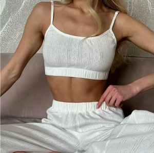 Detail of white pointelle knit lounge set showing breathable camisole and wide leg pants