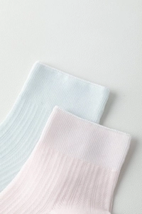 Detailed view of elastic knitted cuffs on light blue and pink silk blend socks