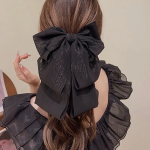 Détail d'une grande pince à cheveux nœud noir avec fils métalliques argentés