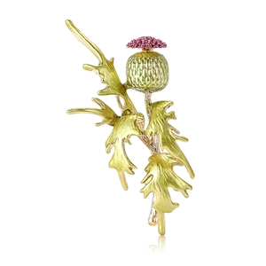Elegant gold thistle brooch with green buds and purple petals on white background