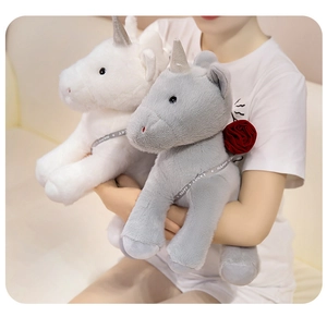 Detailed plush unicorn toys in white and grey with red rose and decorative ribbons