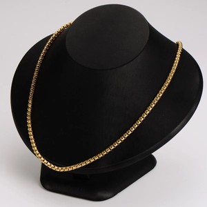 Minimalist gold box chain necklace displayed on a professional black mannequin stand