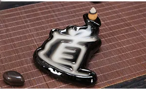 Macro detail of smoke flowing to form the character Tao on black ceramic incense burner