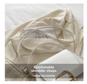 Detail shot of the white saddle bag showing gold buckle and fine leather texture