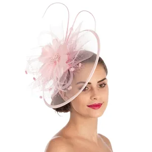 Detailed view of pink floral fascinator with mesh veil and fabric flowers on model
