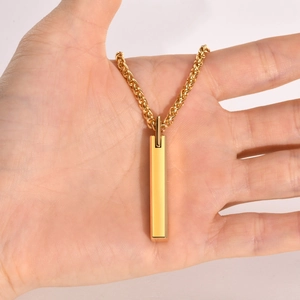 Close-up of a hand holding a minimalist gold tungsten bar pendant with twisted chain