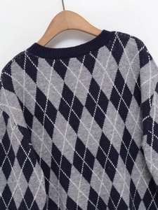 Detail of classic navy and grey argyle knit texture on a soft V-neck long sleeve sweater