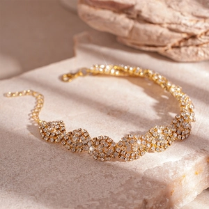 Macro shot of gold-plated geometric link bracelet with shimmering zircon stones and lobster clasp
