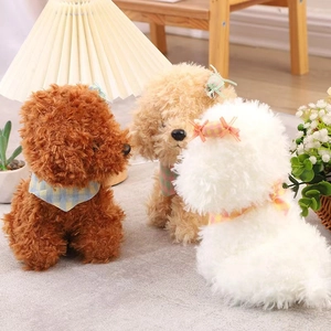 Three plush toy puppies in brown and white colors wearing plaid scarves on a wooden table