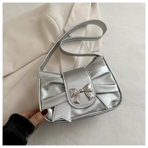 Dettaglio della borsa a spalla argento metallizzato con fiocco elegante e pieghe