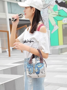Ethnic style butterfly canvas handbag with striped strap for women in outdoor street view