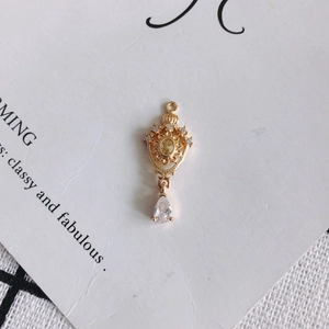 Detail of 18K gold-plated crown pendant with yellow zircon and white teardrop stone