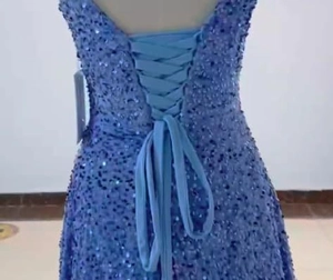 Detail of the back cross-strap design on a blue sequined A-line evening ball gown